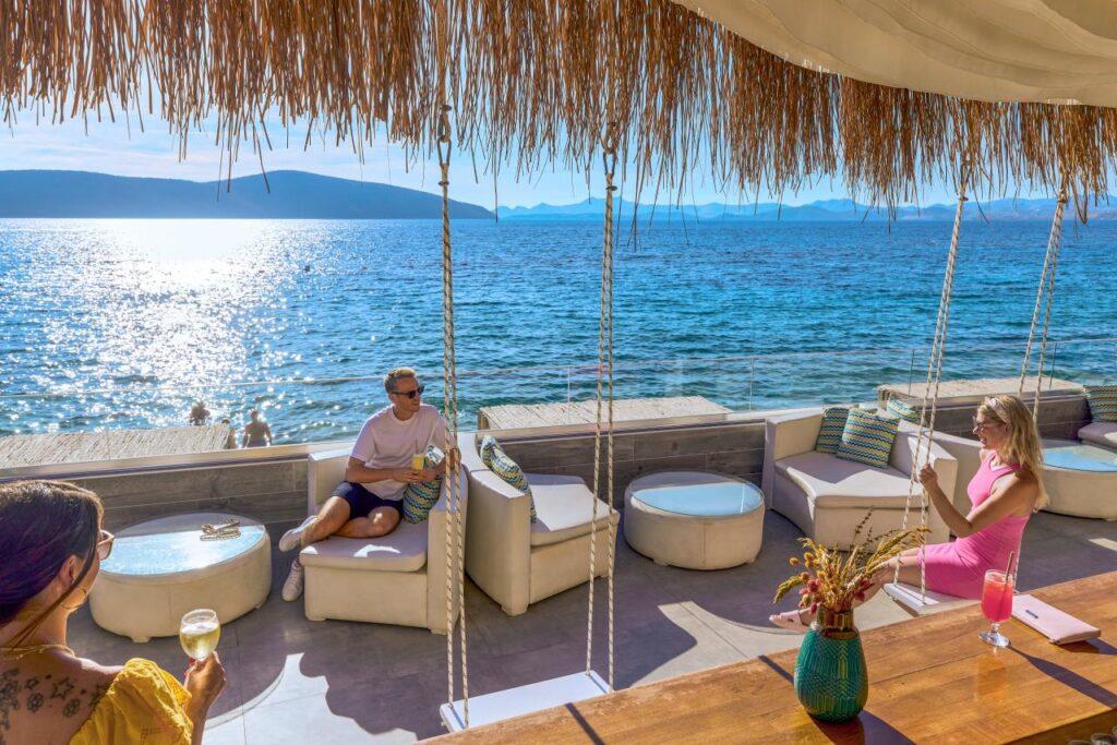 TUI MAGIC LIFE Bodrum – Gäste relaxen bei ihrem All Inclusive Urlaub in der Türkei in einer Bar mit Blick auf das Meer.