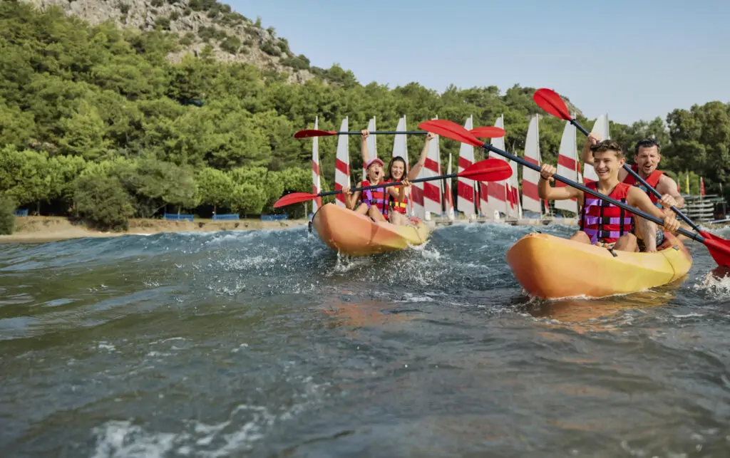Gäste beim Kanufahren im TUI MAGIC LIFE Sarigerme in der Türkei, umgeben von grüner Landschaft und klarem Wasser – ideal für Aktivurlauber und Wassersportfans.