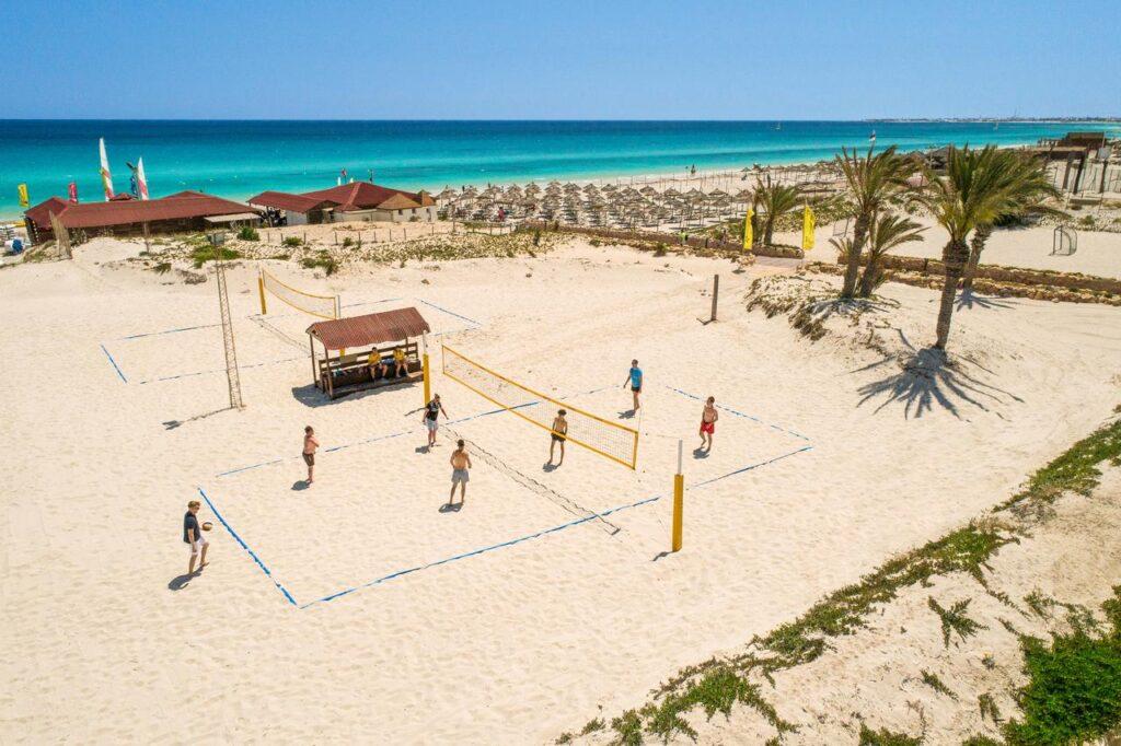 Beachvolleyball-Spielfeld am weißen Sandstrand des TUI MAGIC LIFE Penelope Beach mit Netz, Volleyballspielern, Palmen und türkisblauem Meer im Hintergrund