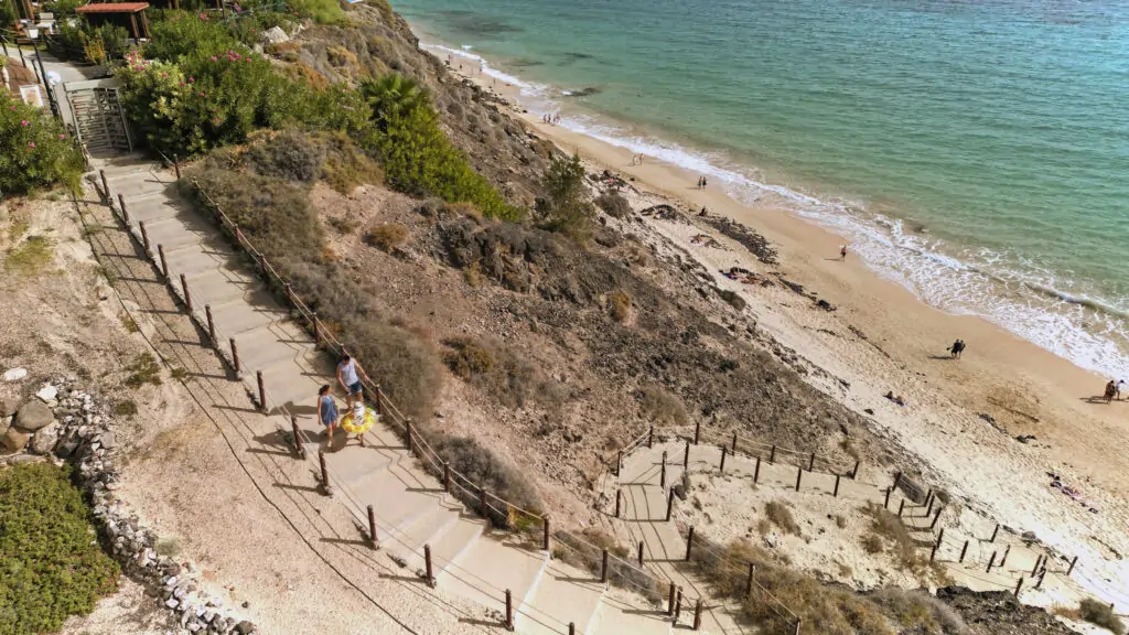 Beste Reisezeit für Fuerteventura: Zugang über einen Holzweg zum Sandstrand am Atlantik.