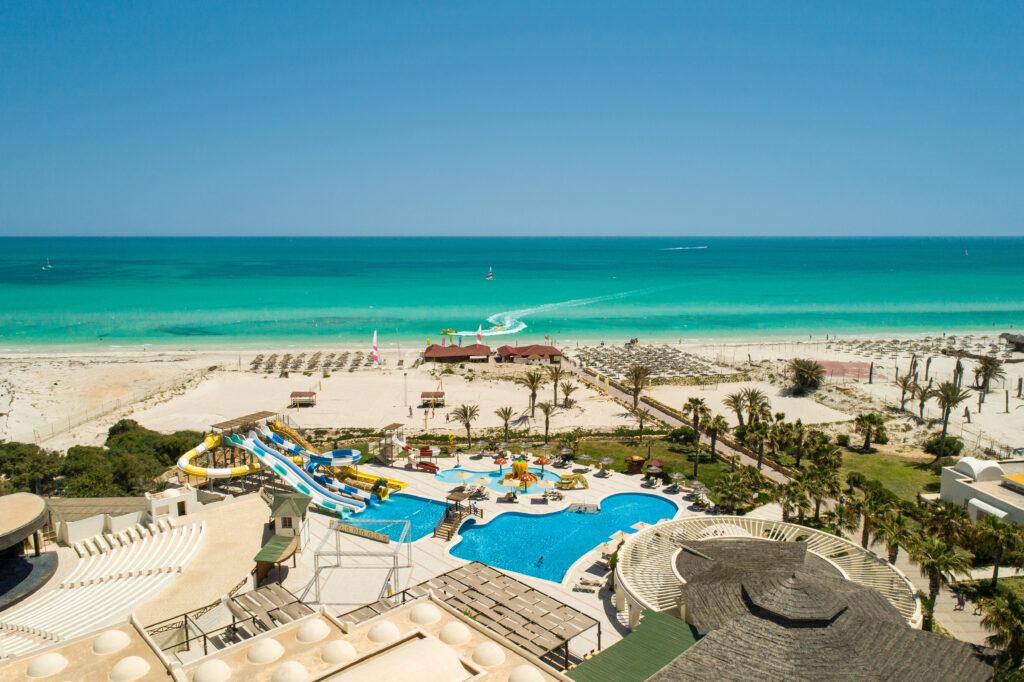Blick auf die Poolanlage des TUI MAGIC LIFE Penelope Beach mit blauem Pool, Sonnenschirmen, Palmen und direktem Zugang zum türkisfarbenen Meer und weißen Sandstrand