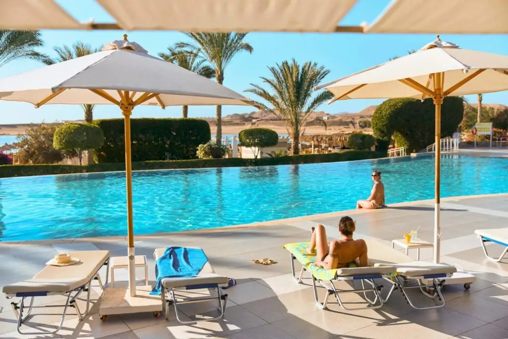Poollandschaft mit Palmen – entspannter Rückzugsort, Tipp: frühzeitig klären, wann Urlaub buchen.