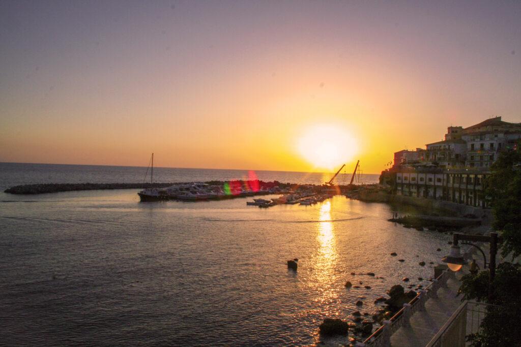 Sonnenuntergang im Hafen von Diamante, Kalabrien - die für Street Art und Peperoncino-Festivals berühmte Stadt mit ihrer malerischen Strandpromenade, über 150 Wandmalereien schmücken die Altstadt, Boote im goldenen Abendlicht des tyrrhenischen Meeres