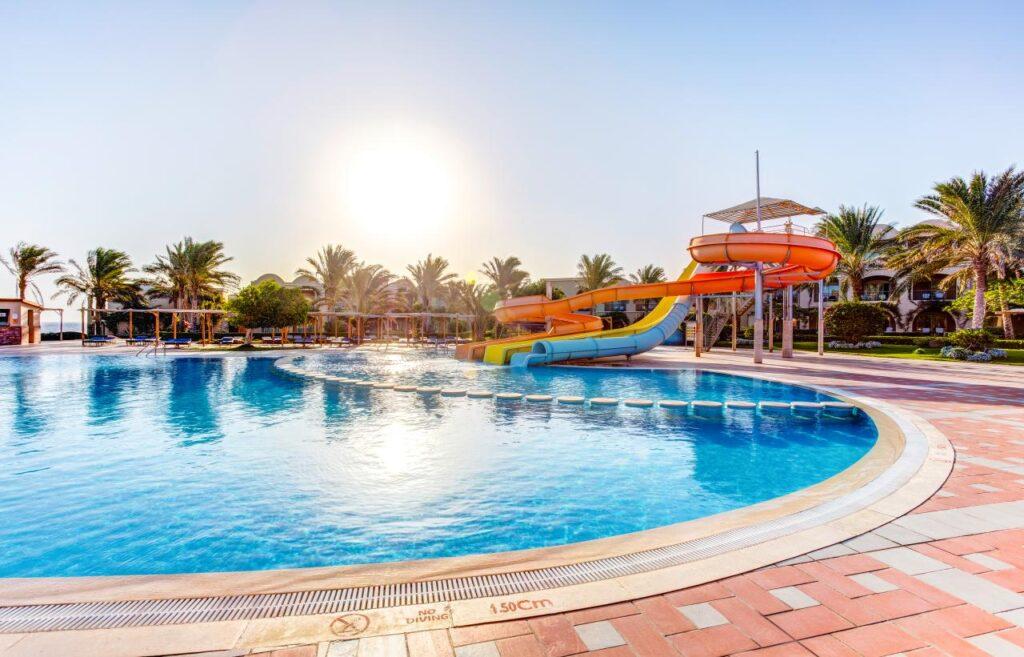 Poolanlage mit Wasserrutschen im TUI MAGIC LIFE Kalawy in Hurghada, umgeben von Palmen und Meerblick am Roten Meer