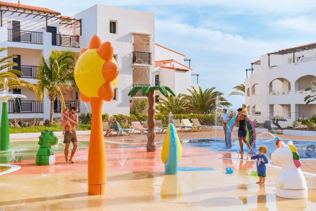 Kinder-Wasserspielplatz mit bunten Wasserfontänen und Figuren in Hotelanlage auf Fuerteventura Kanaren