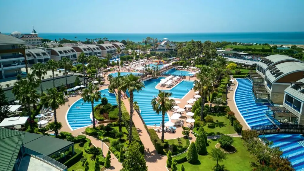 Luftaufnahme TUI MAGIC LIFE Jacaranda: Geschwungene Pool-Anlage mit Swim-up Zimmer Türkei, Palmen und Strandnähe an der türkischen Riviera