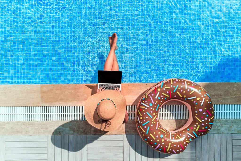 Frau nutzt KI Assistenten für detaillierte Fragen zur Urlaubsplanung am Laptop