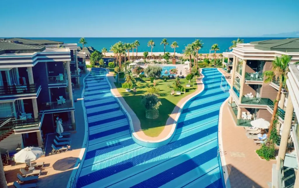 TUI MAGIC LIFE Masmavi Antalya: Drei Ansichten zeigen Poollandschaft mit Meerblick, Swim-up Zimmer Türkei mit Lagoon Pool-Zugang und bunte Wasserrutschen-Anlage für Familien
