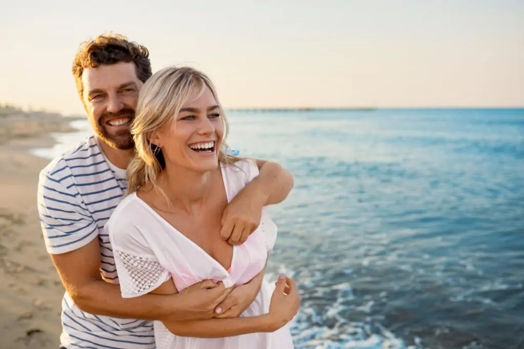 Glückliches Paar am Strand der türkischen Riviera bei Sonnenuntergang, romantische Atmosphäre für Swim-up Zimmer Türkei Urlaub, Meer im Hintergrund