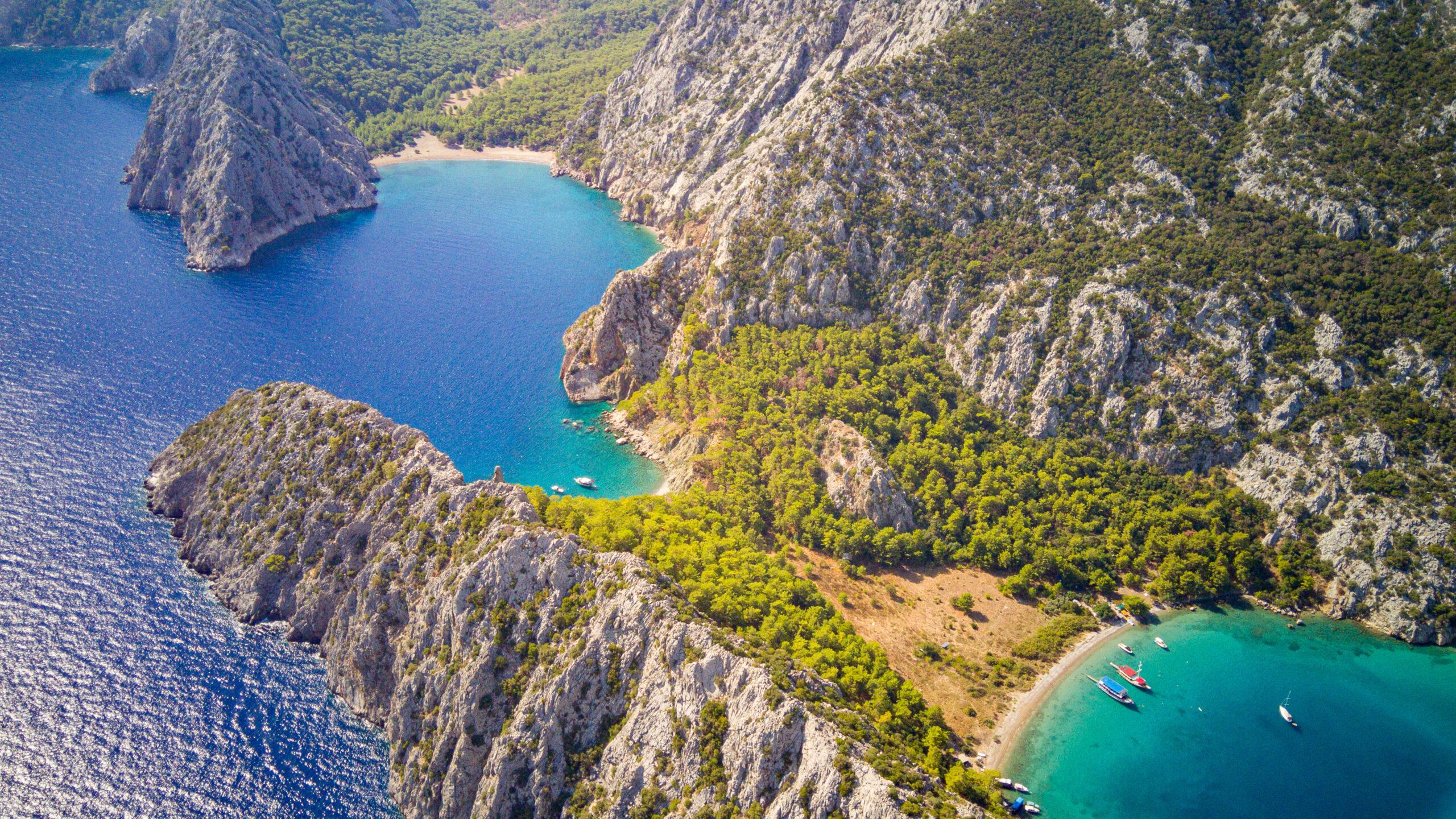 Luftaufnahme zweier türkisfarbener Buchten eingerahmt von steilen Klippen
